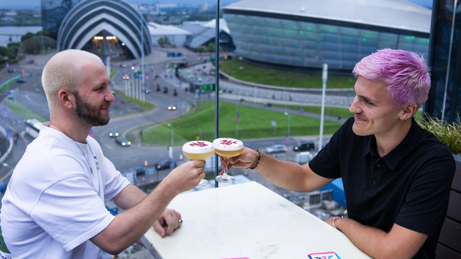 Friends toasting with All In stencilled cocktails overlooking the SEC